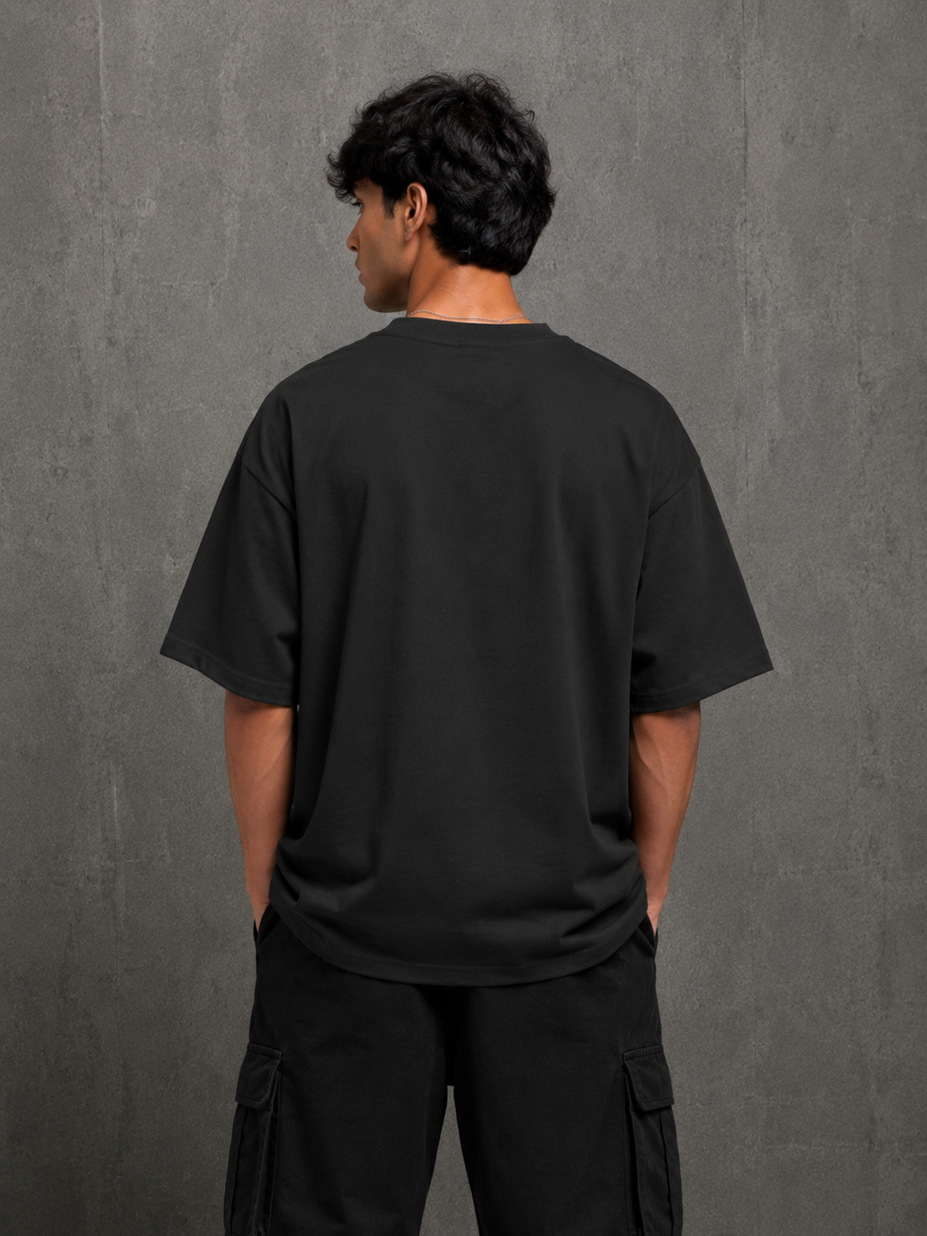 Model wearing black Pizza Glitch oversized t-shirt showing clean plain back by Snitch Glitch