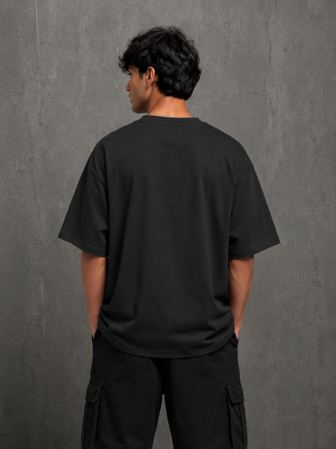 Model wearing black Pizza Glitch oversized t-shirt showing clean plain back by Snitch Glitch