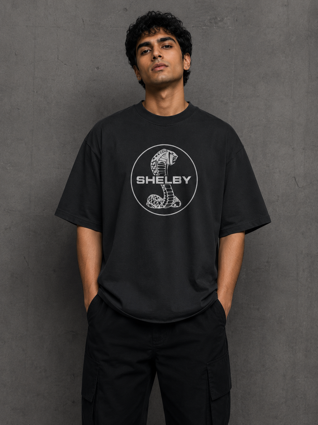 Model wearing dark Mustang Shelby oversized t-shirt with blue muscle car back artwork by Snitch Glitch
